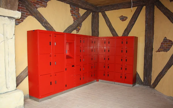 Archive photograph of red theme-park lockers arranged in a corner beneath exposed timber beams.