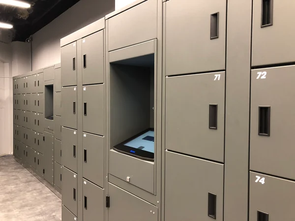 Grey locker doors, handles and a recessed touchscreen at an earlier museum installation.